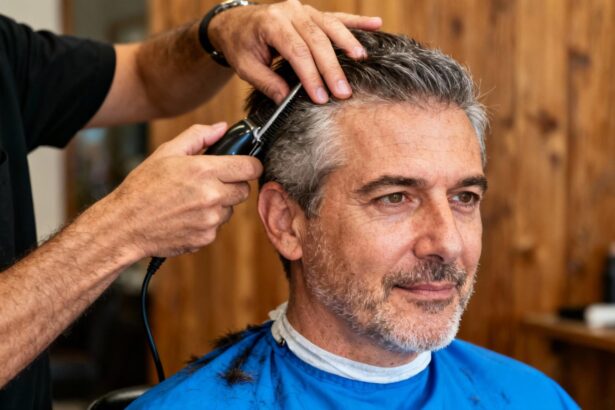 Homme d'âge mûr avec visage ovale portant une chemise bleue vive lors d'une coupe de cheveux chez le coiffeur